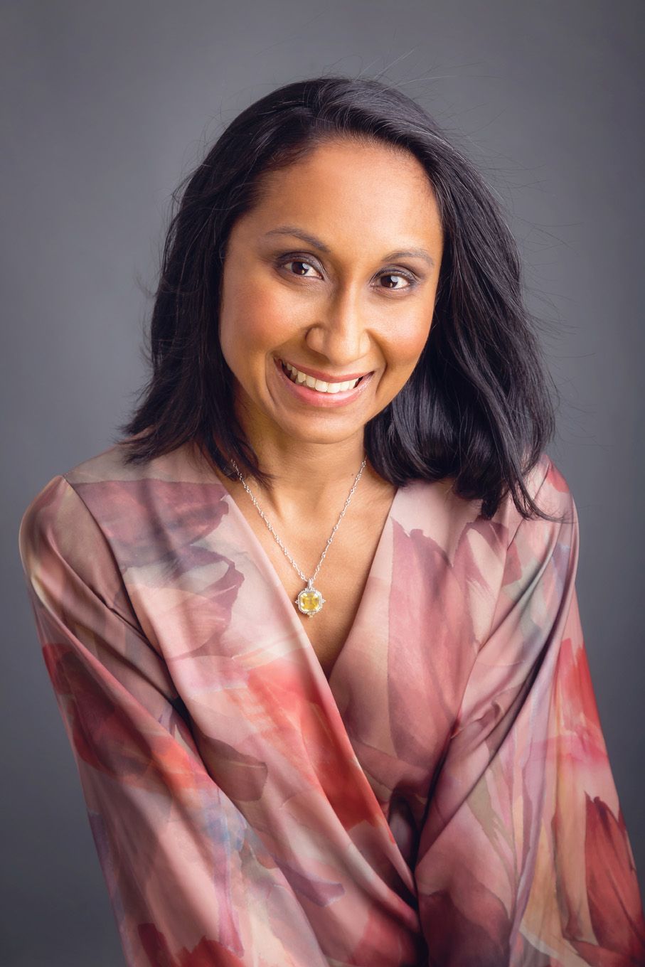 A portrait of a woman taken in a studio set up with backdrop and lighting equipment